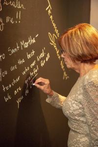 Friends write personal notes to Martha on the chalkboard wall