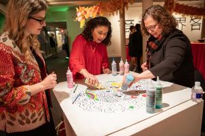 Kathryn Mitchell, Iliana Carpenter and Dr. Anca Pacuraru sand-paint a Chinese mandala